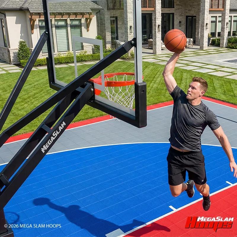 Player dunking on a Mega Slam in-ground hoop on a home basketball court